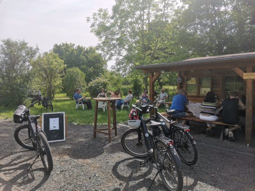 ... und schon parken die ersten Räder Fahrräder vor der Hütte, hinten Leute die sitzen